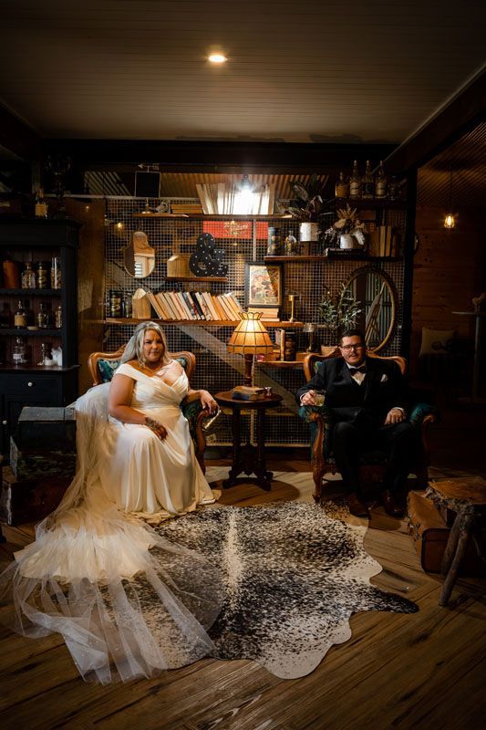 A bride and groom are sitting in chairs upstairs at Aberfeldy Barn