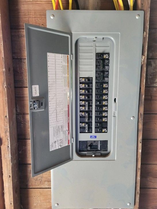 A electrical box with the door open is hanging on a wooden wall.