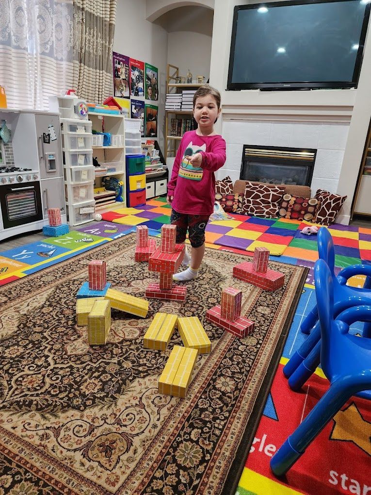 Child playing with blocks on a rug. Bright colors. Indoor setting.