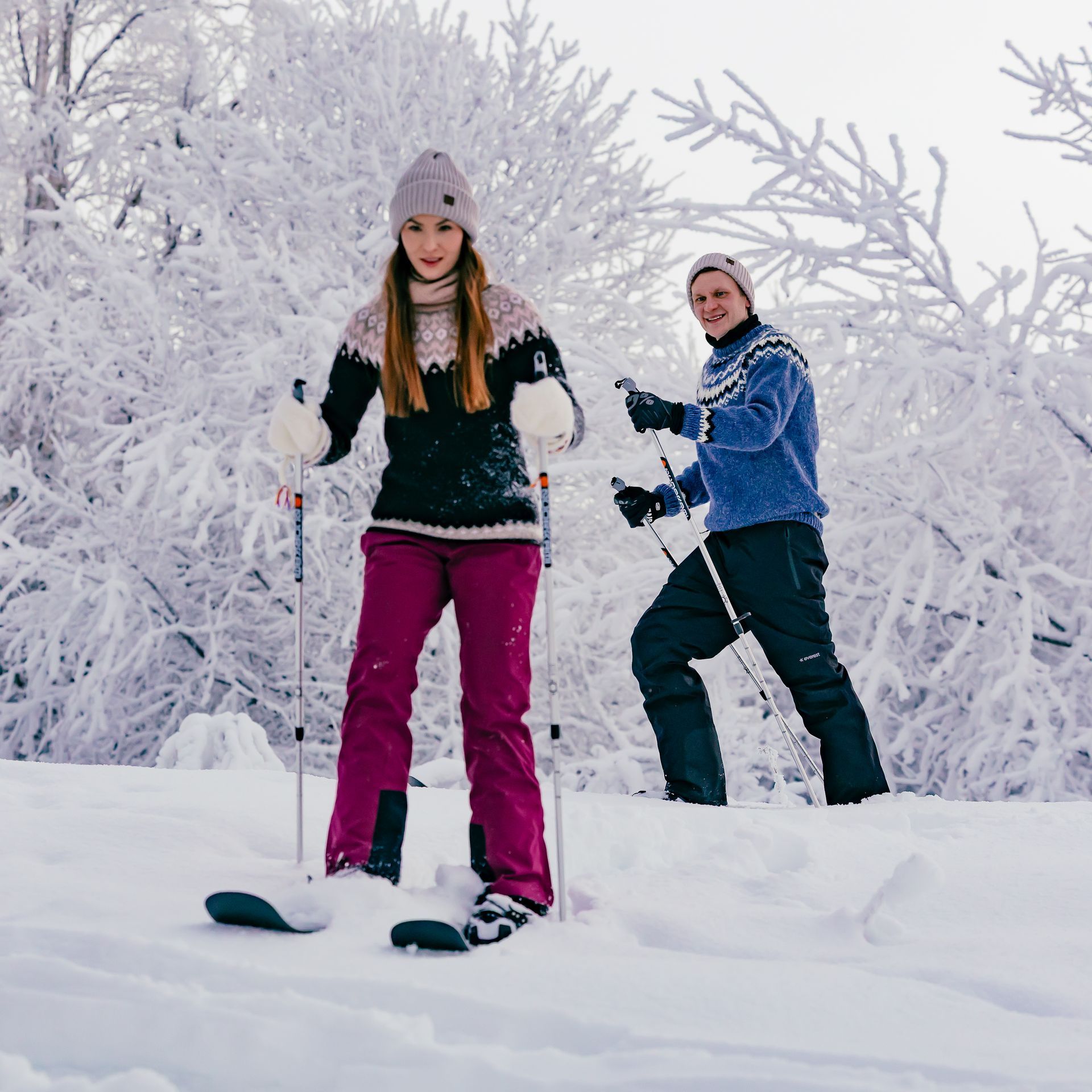 Couple snowshoeing in snowy landscape.