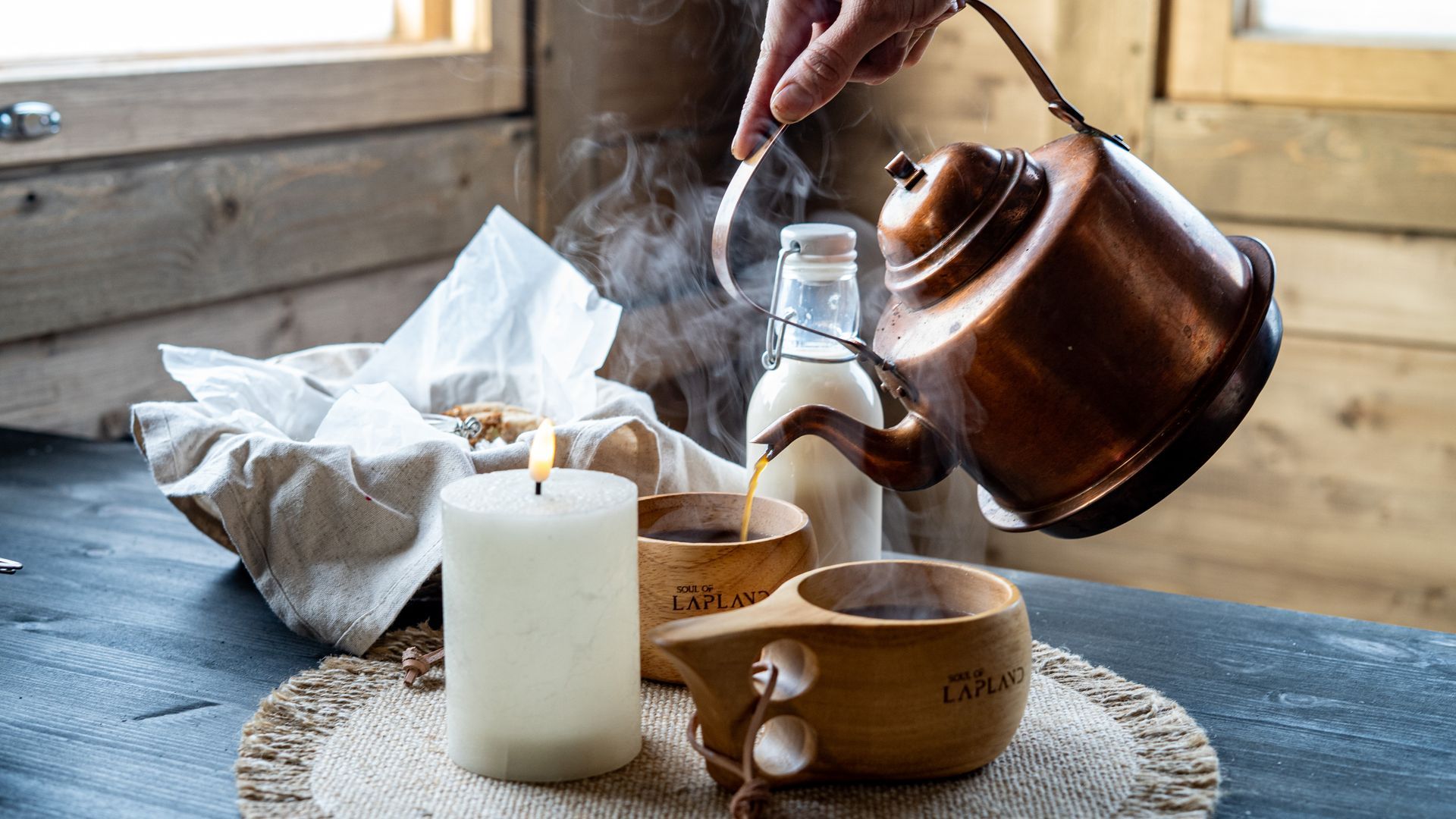 Serving coffee to kuksa mugs form a copper pot 