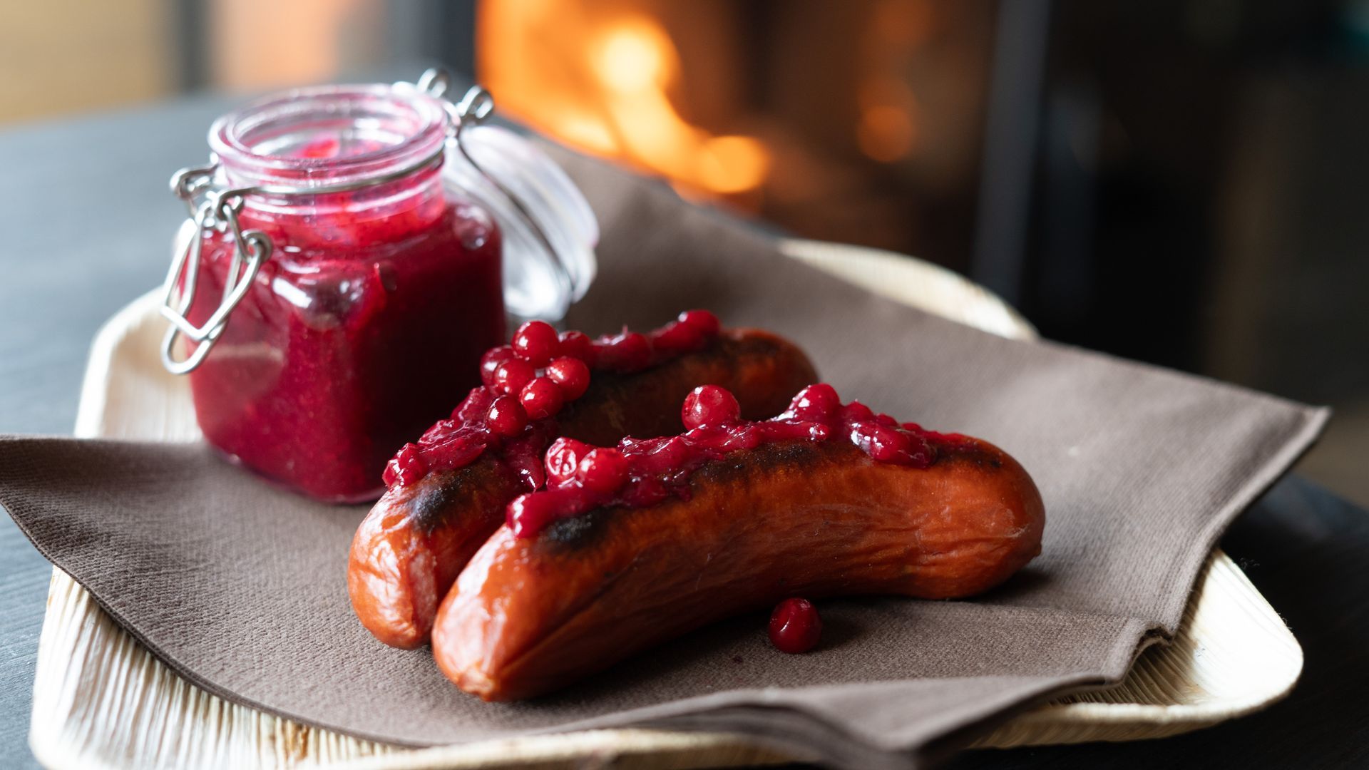 Reindeer sausage and lingon berry jam with fire in the background