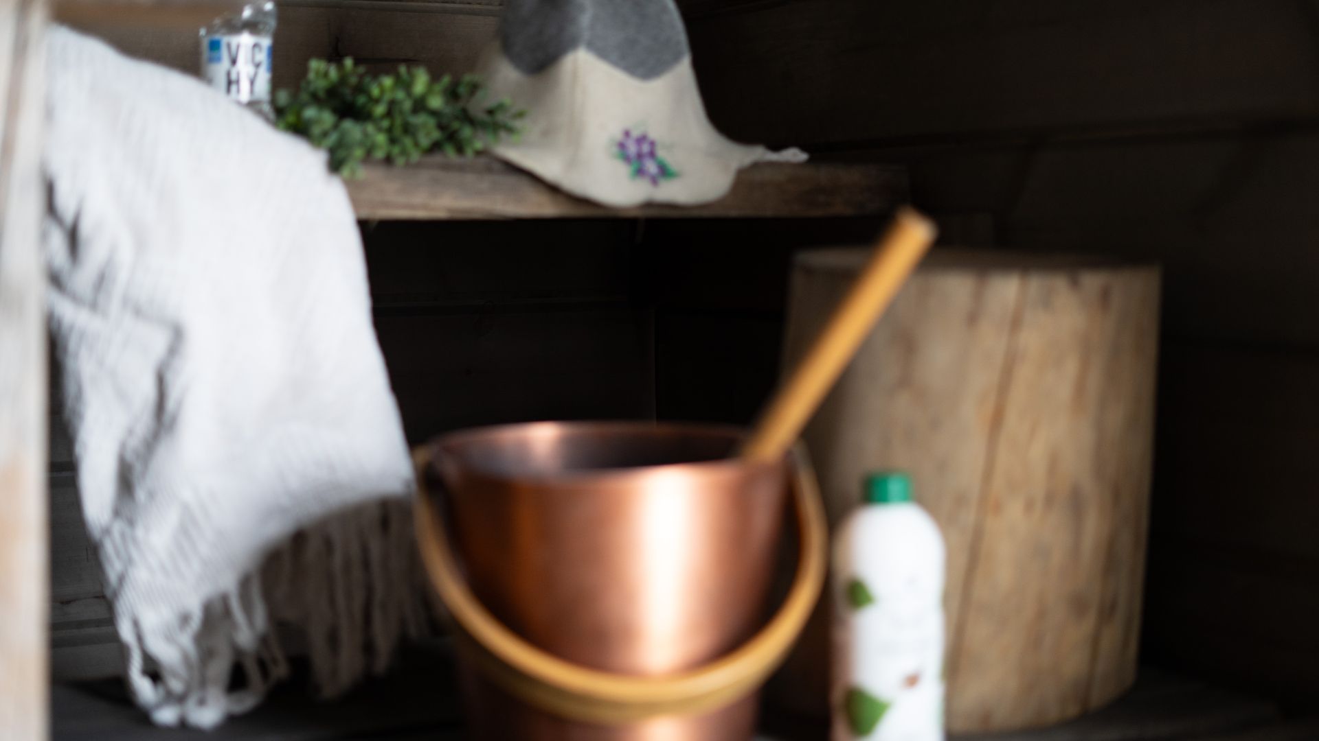 Sauna bucket and sauna scent with a towel inside a sauna