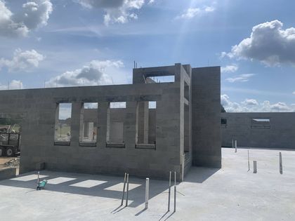 fully built concrete masonry unit building on a sunny completed construction site under a blue sky