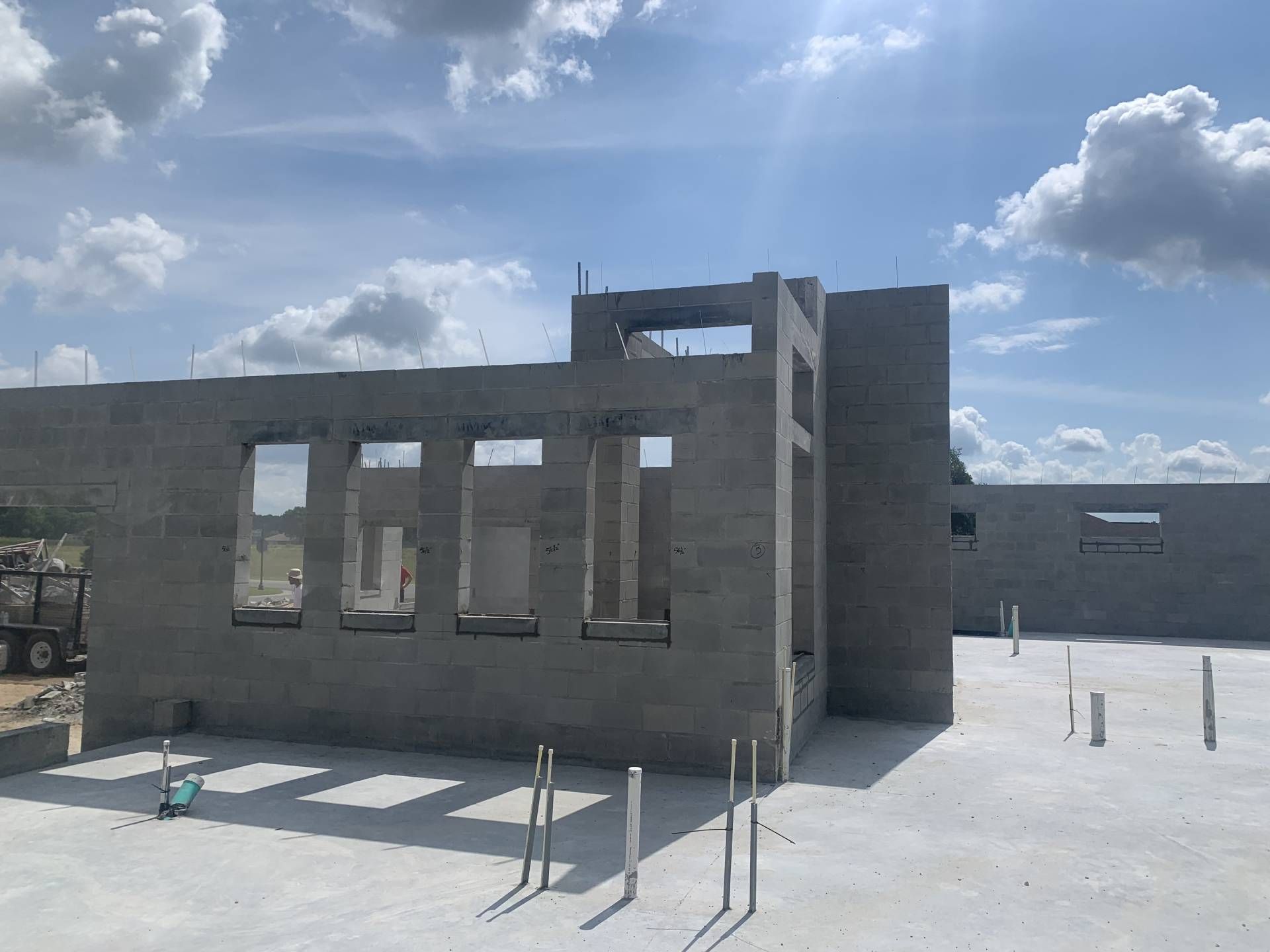 fully built concrete building under a bright blue sky with scattered clouds
