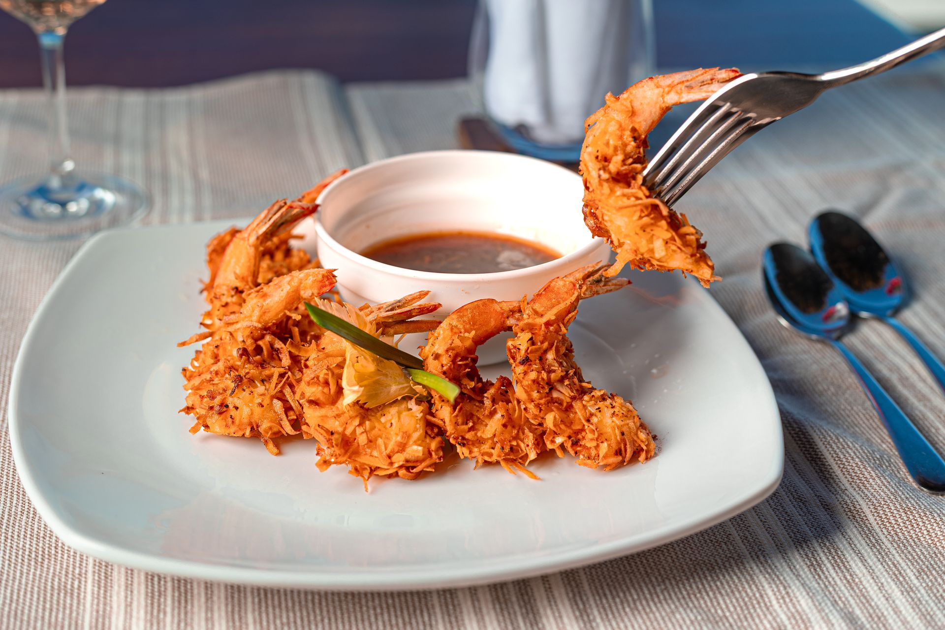 Fork lifting a crispy fried egg from a white plate in a restaurant setting