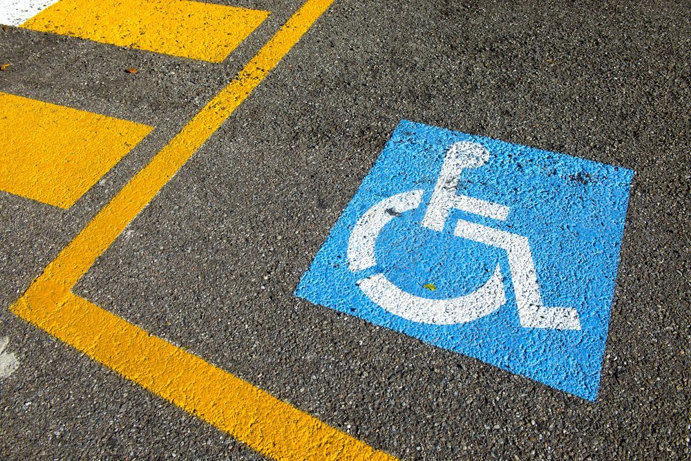 a blue and white handicap sign is painted on the road
