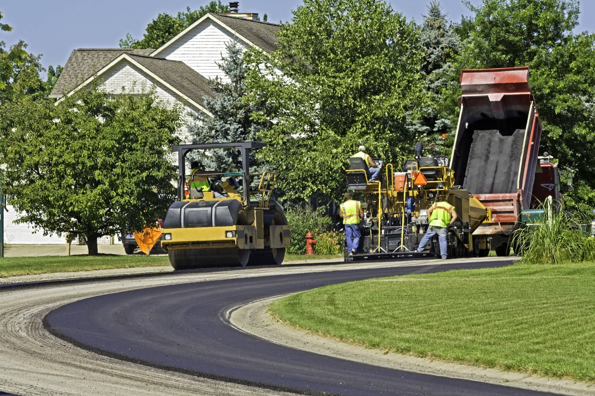 a dump truck is being used to dump asphalt on a road