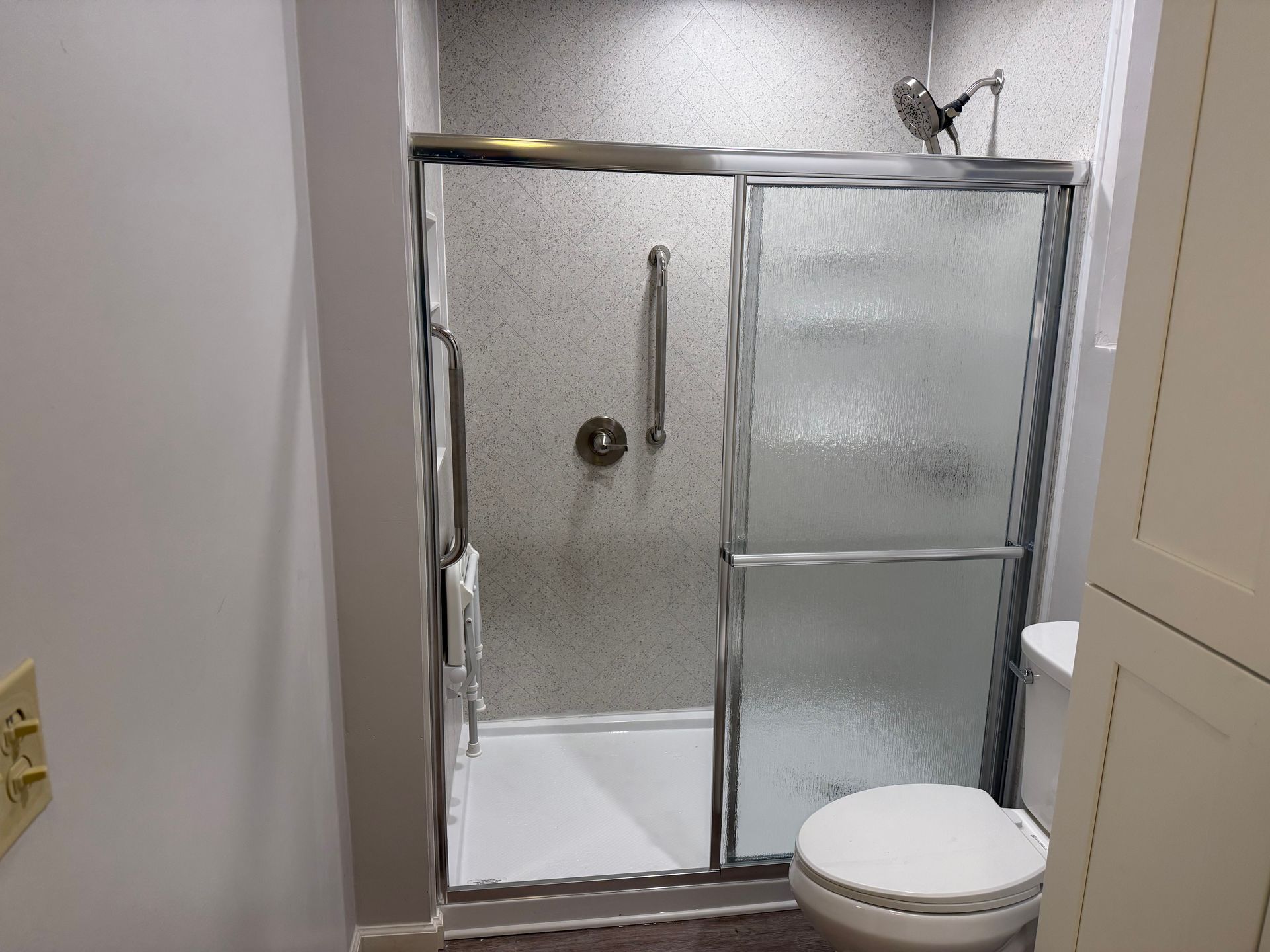 Small Fibo bathroom with a frosted glass shower stall and a white toilet in front.