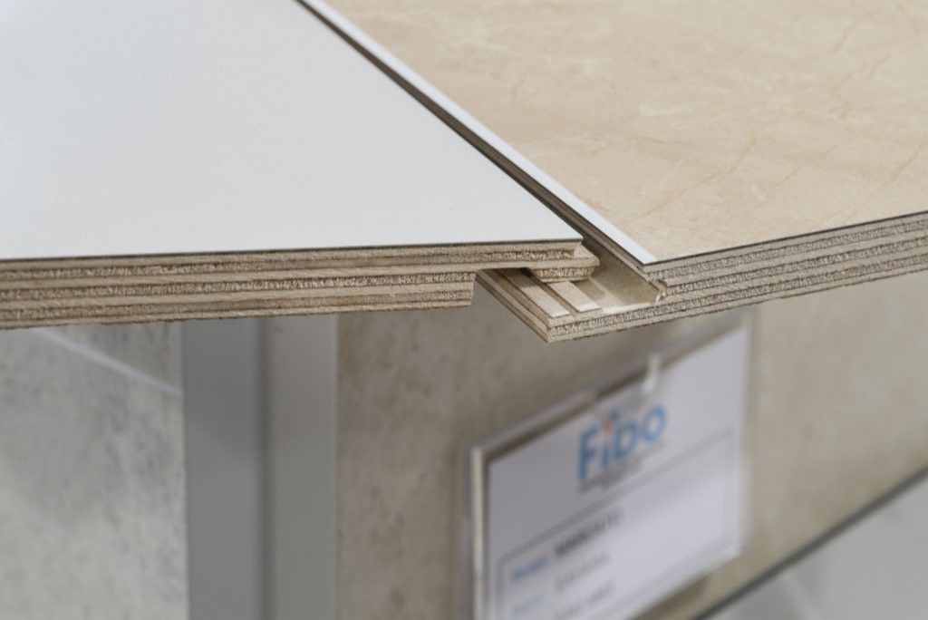Two plywood wall panels with a tongue-and-groove locking system, showing a light gray side and a patterned beige surface.