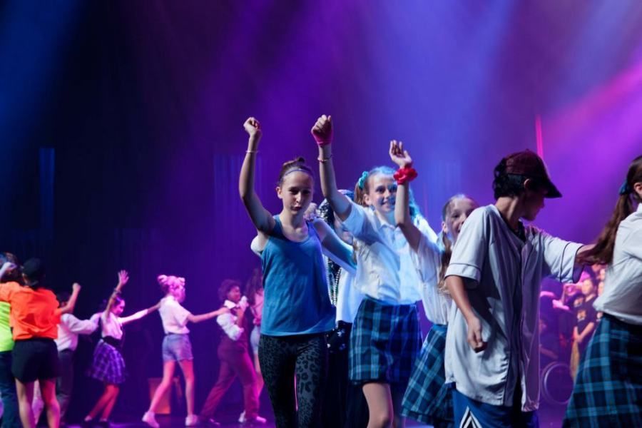 A group of young people are dancing on a stage.