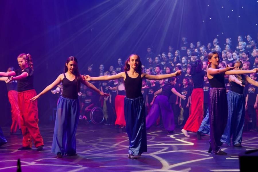 A group of young girls are dancing on a stage.