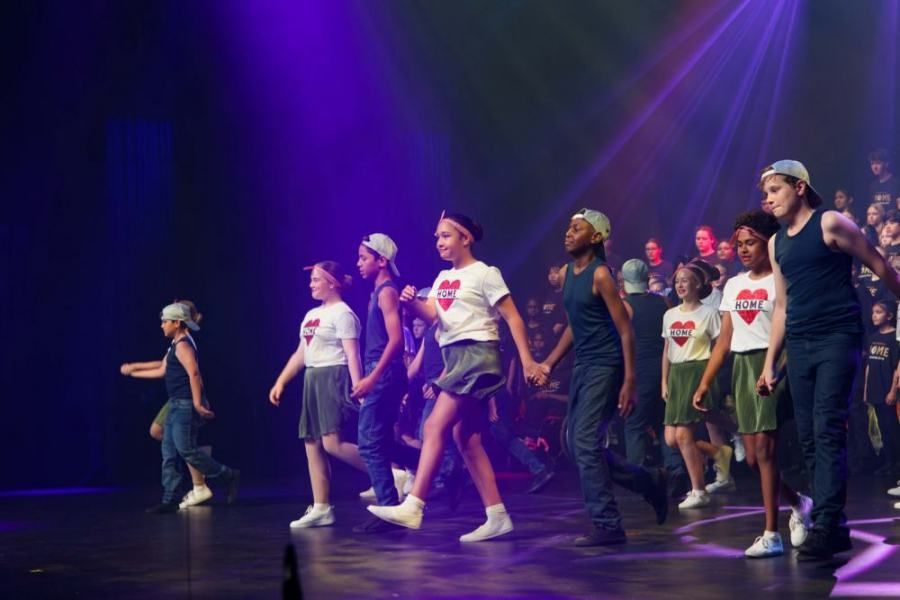A group of young people are dancing on a stage.
