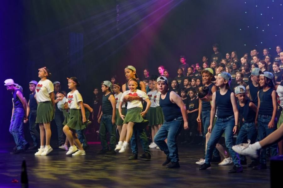 A group of young people are dancing on a stage.