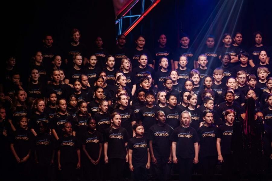 A large group of people wearing black shirts with the letter m on them