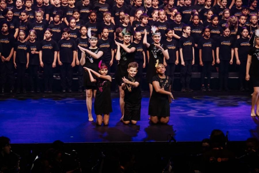 A large group of children are standing on a stage.