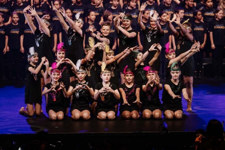 A group of young girls are posing for a picture on a stage.