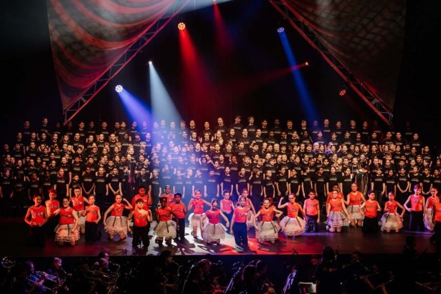 A large group of people are dancing on a stage.