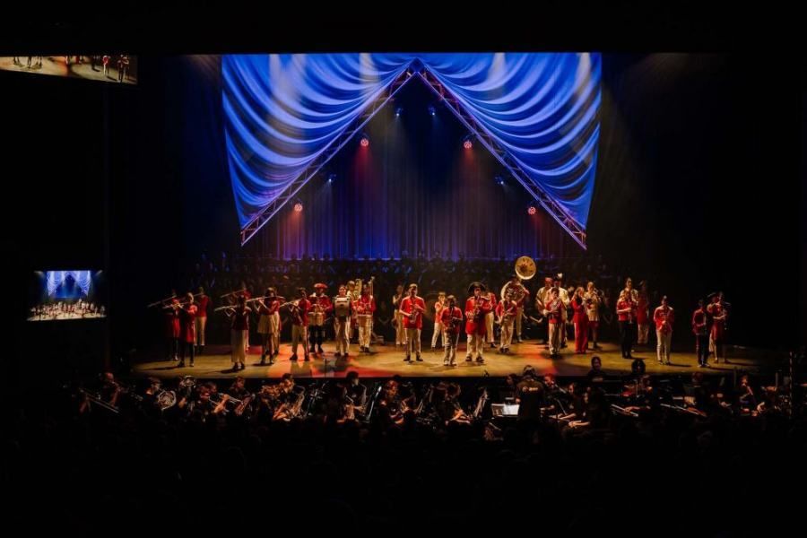 A large band is playing on a stage in front of a crowd.
