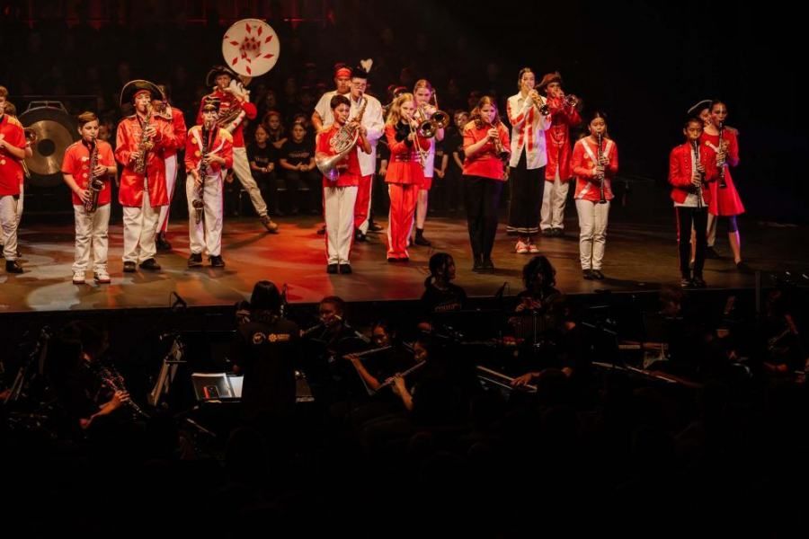 A group of people are standing on a stage playing instruments.