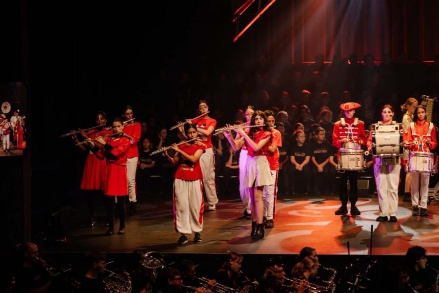A group of people are playing instruments on a stage in front of a crowd.
