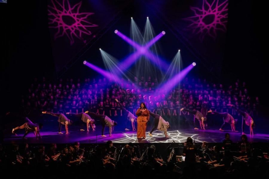 A woman is singing on stage in front of a crowd of people.