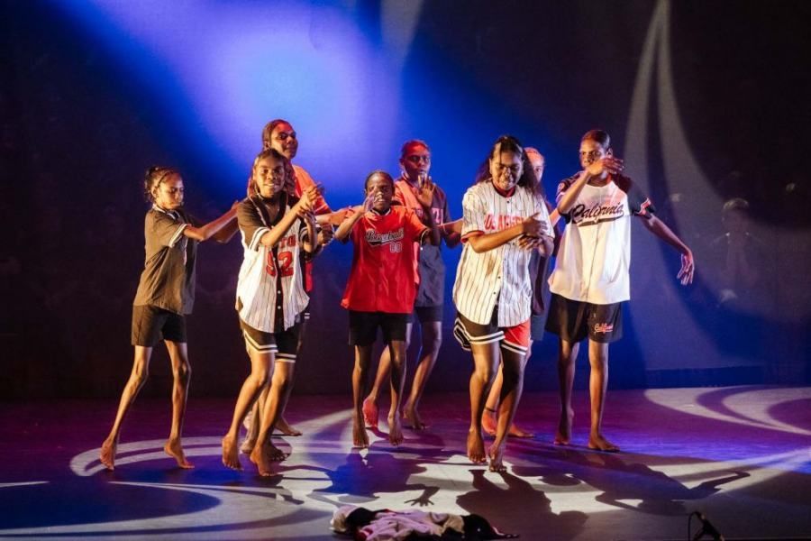 A group of young people are dancing on a stage.