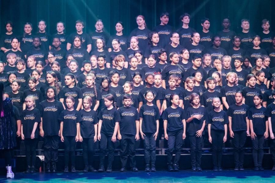 A large group of people are posing for a picture on a stage.