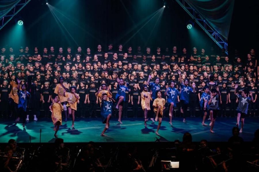 A large group of people are dancing on a stage