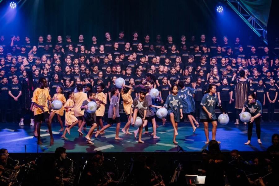 A large group of people are dancing on a stage.