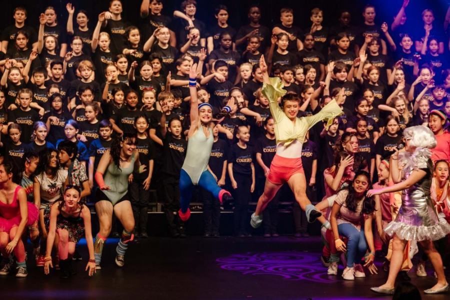 A large group of people are dancing on a stage.