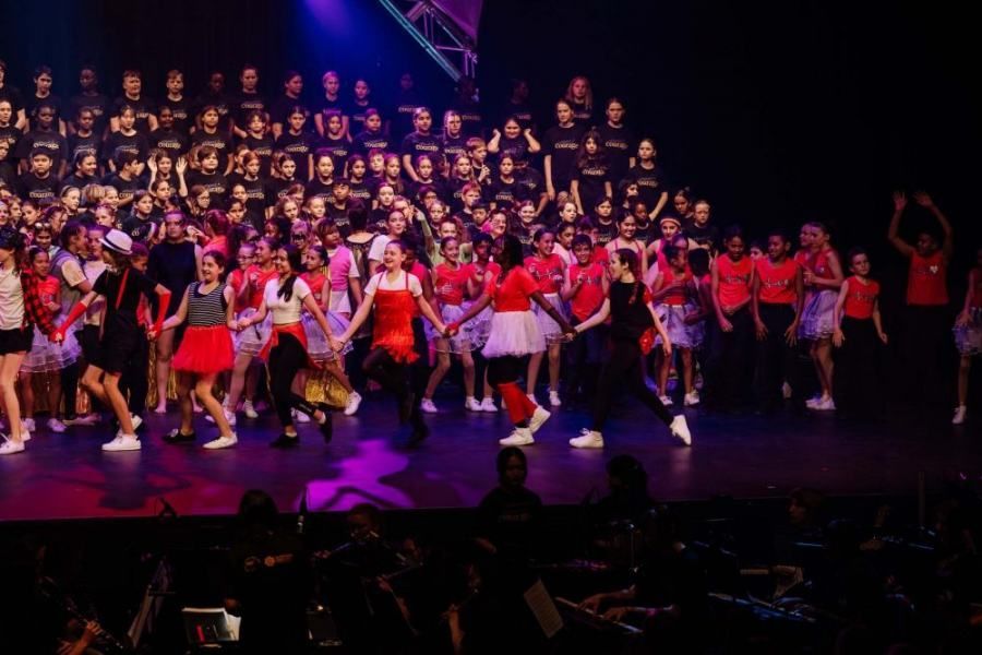 A large group of people are dancing on a stage.