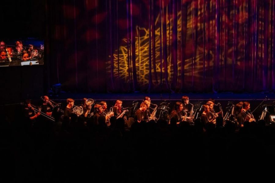 A group of people are sitting in front of a stage.