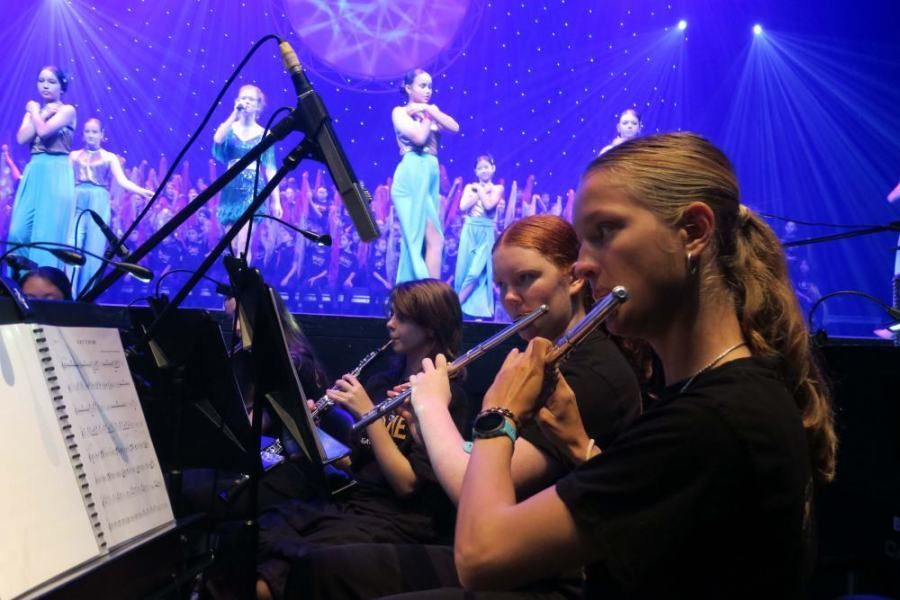 A group of women are playing flutes on a stage