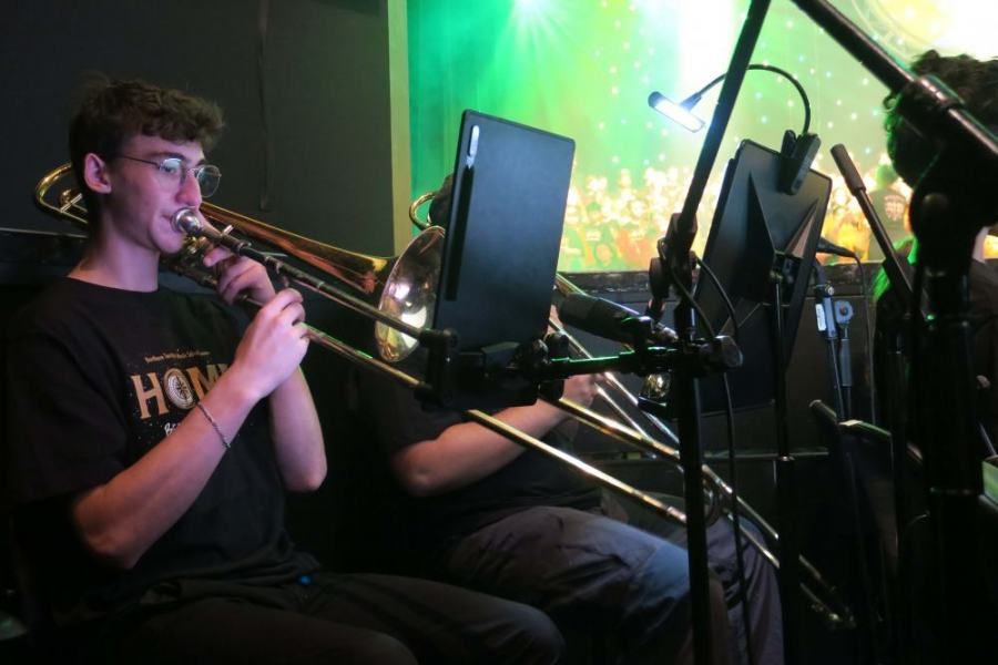 A man playing a trombone with a shirt that says ho on it
