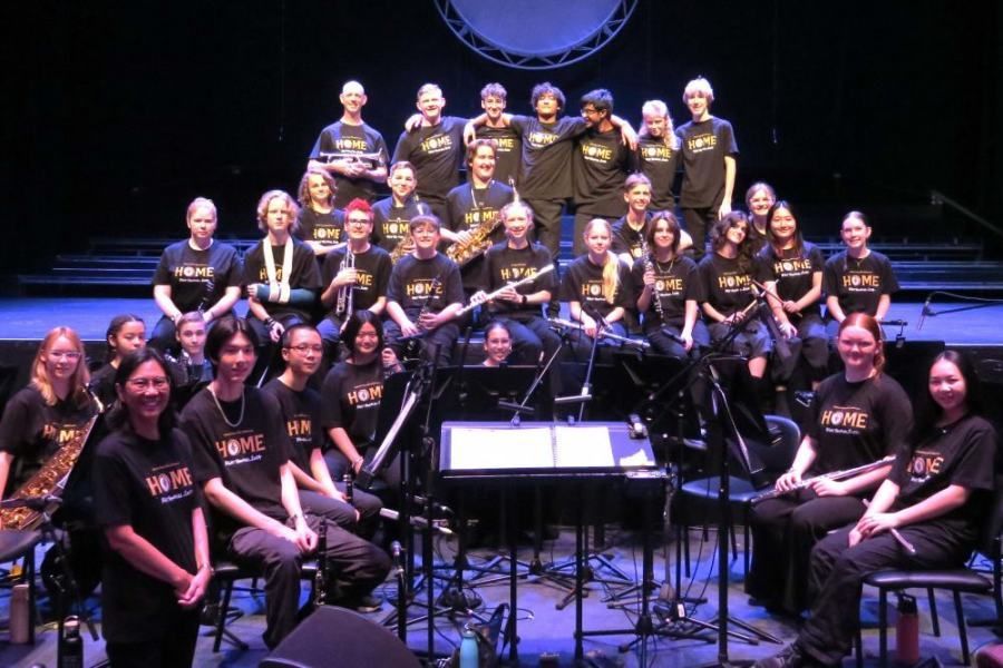 A large group of people are posing for a picture on a stage