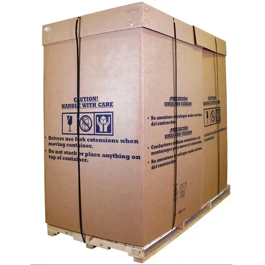Large cardboard shipping container secured with black straps on a wooden pallet; warning labels visible.