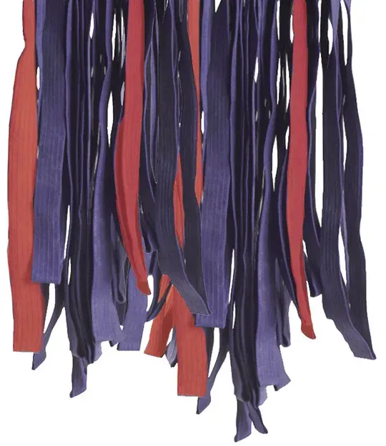 Strips of red, purple, and dark blue fabric hanging from above.