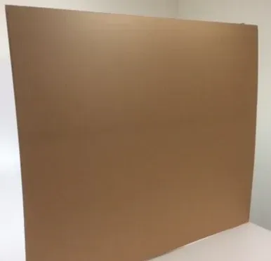 Brown cardboard sheet leaning against a white surface, corner of a room.