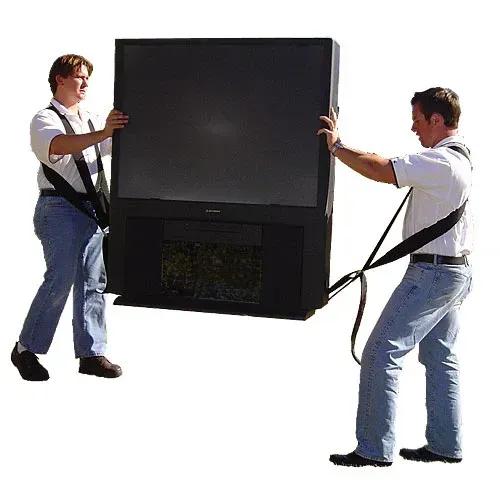 Two people using moving straps to lift a large, black, old-style television.
