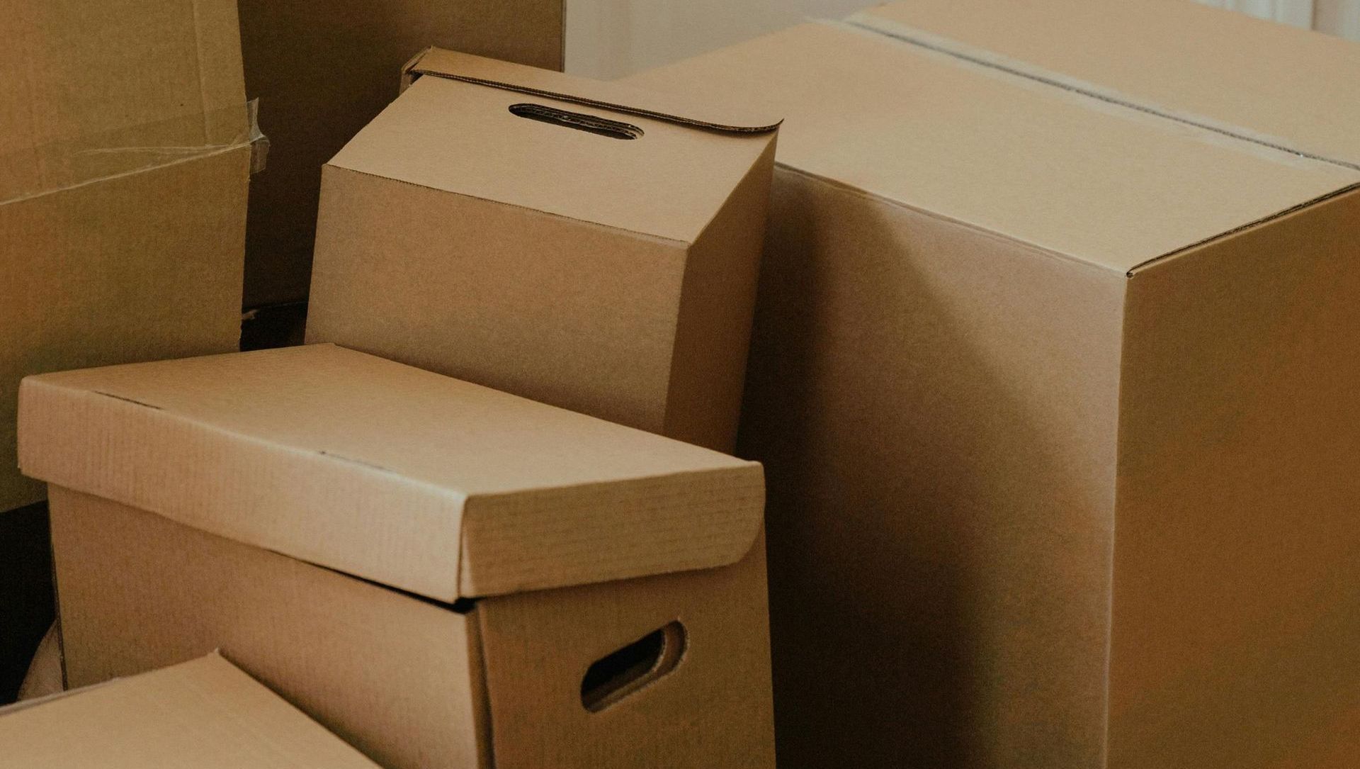 A pile of cardboard boxes are stacked on top of each other.
