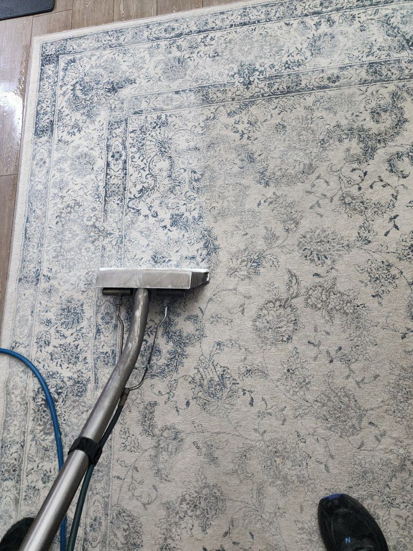 A floor cleaner scrubbing a dirty concrete surface with a squeegee attachment