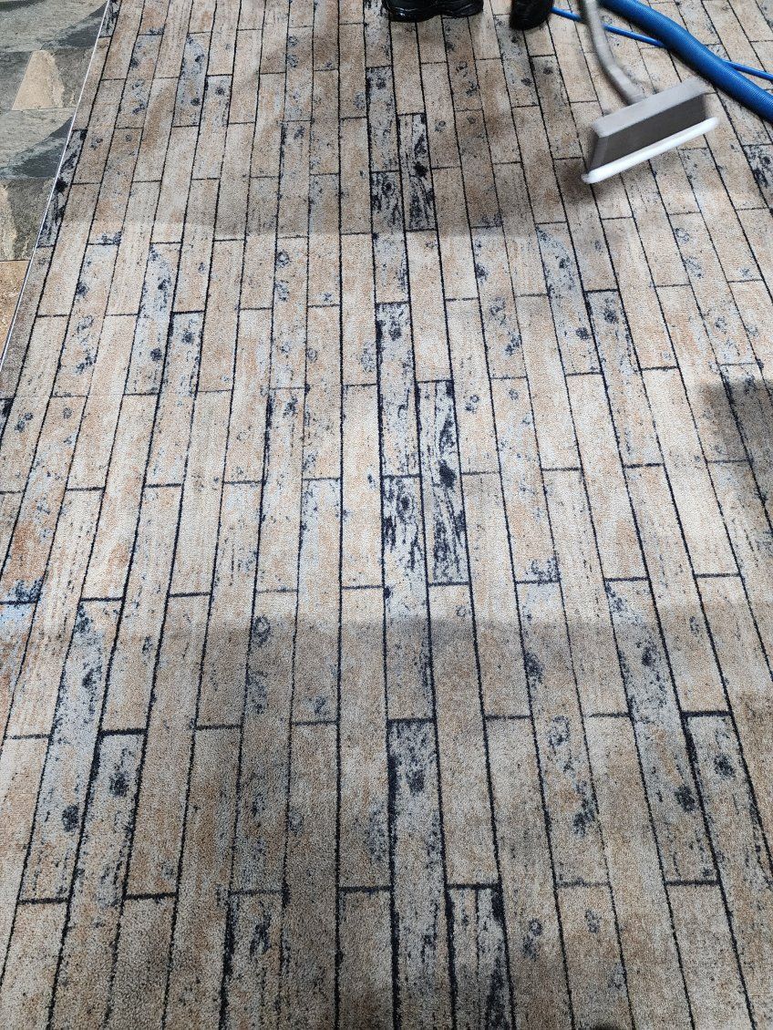 Brick-paved ground with a small metal tray at the upper right and a dark stain near the center