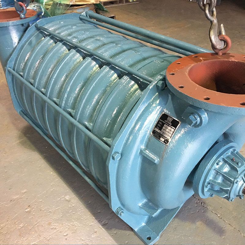 Large blue industrial pump or blower suspended by chains in a workshop.