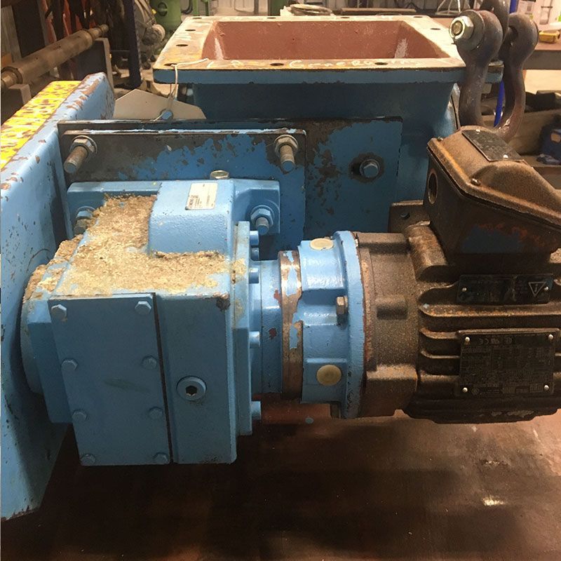 Blue industrial gearbox and motor assembly with attached coupler in a workshop setting