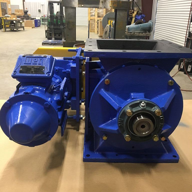 Blue industrial electric motor and large machine housing in a workshop.