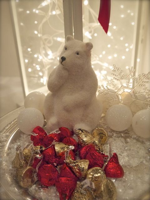 A polar bear is sitting on top of a bowl of kisses. A polar bear is sitting on top of a bowl of kisses.