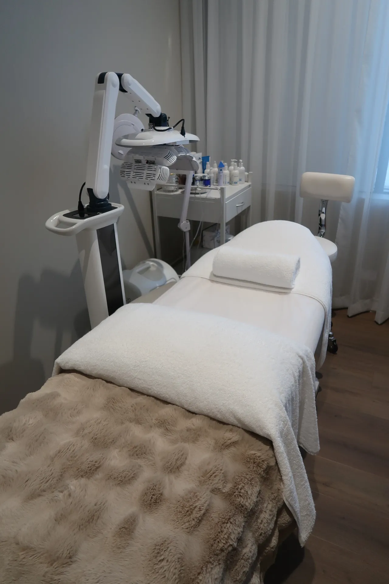 Treatment room with a bed, equipment, and a small table.