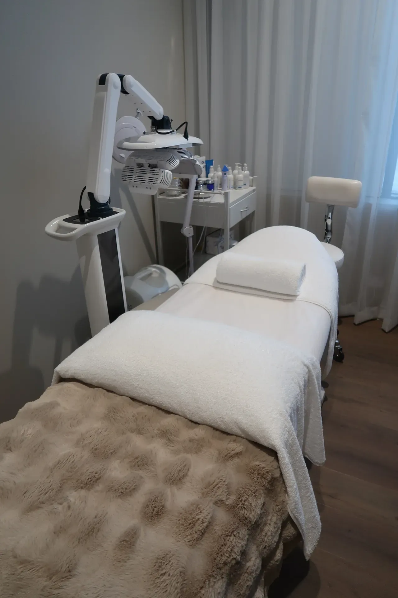 Spa treatment room with a massage table, equipment, and a stool.