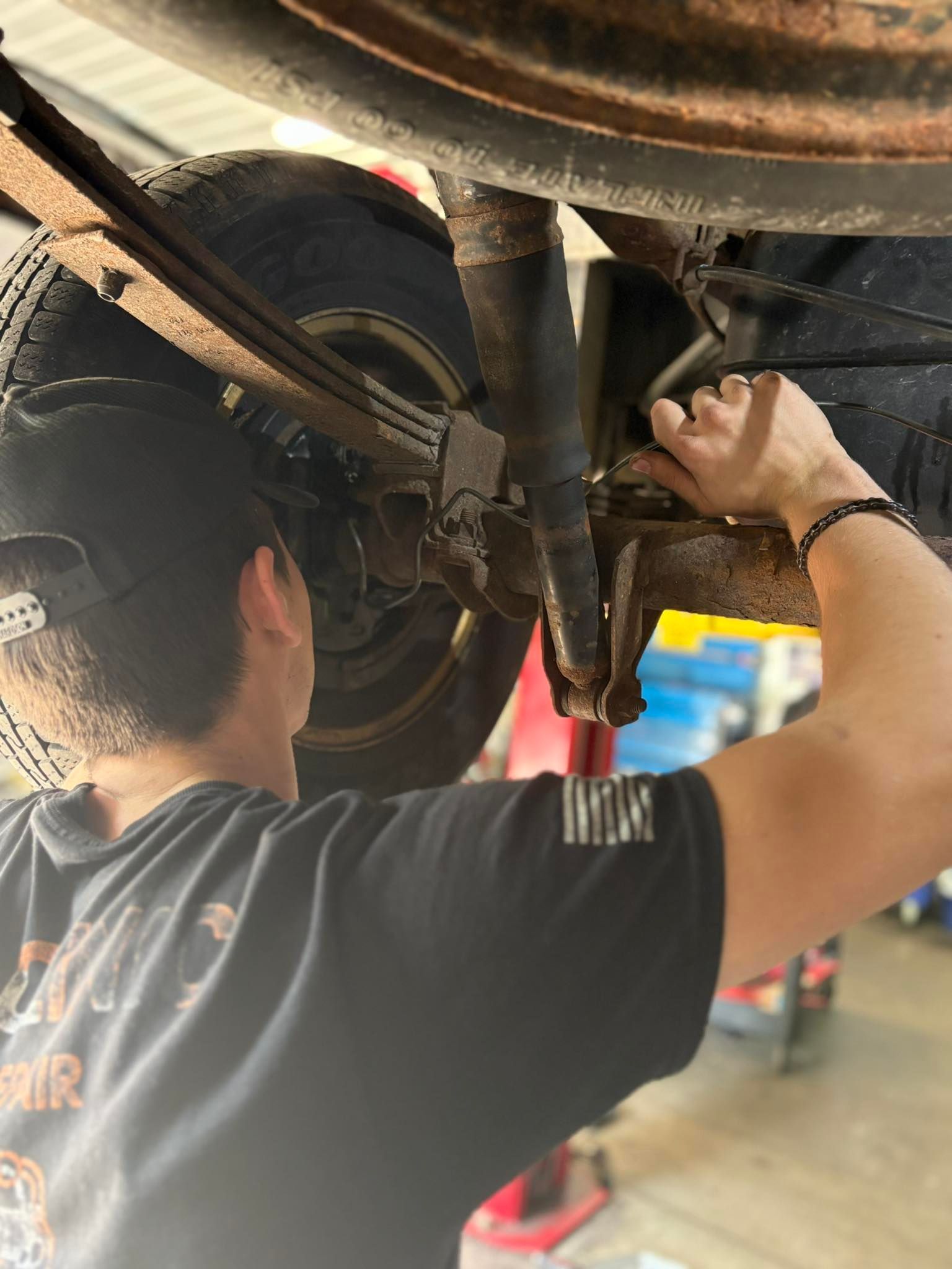 Mechanic Working on the Undercarriage of a Vehicle | Car Clinic